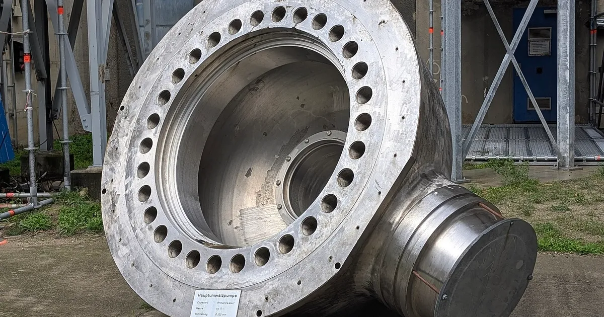 Large machined pump casing with a bolted flange and bore standing on its side outdoors, an example of large pump casing machining